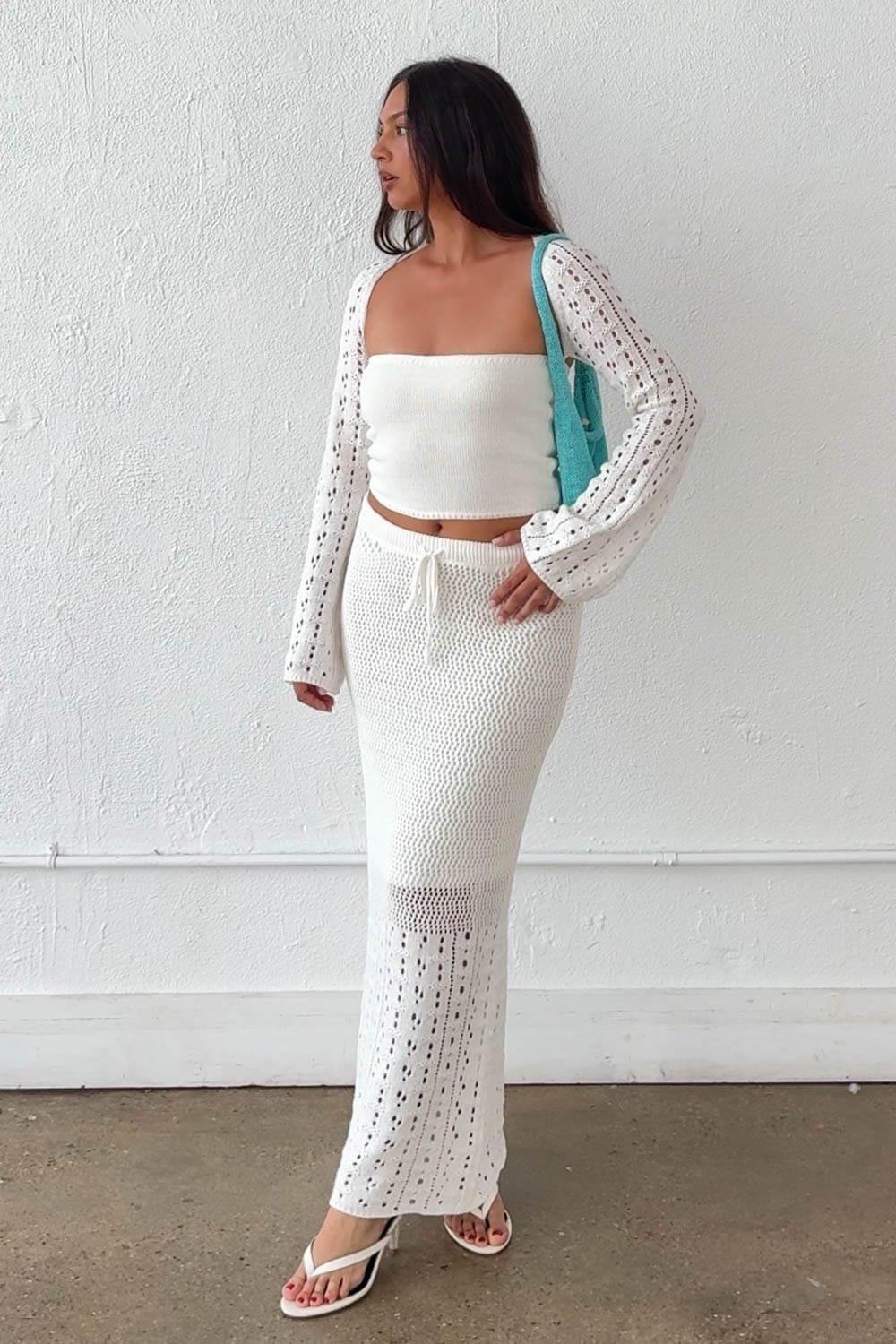 A Chic And Effortlessly Bohemian Crochet Set Featuring A Ribbed Knit Strapless Crop Top And A Matching Open-Knit Maxi Skirt With Eyelet Detail At The Hem. The Open-Knit Cardigan Overlay, Halter Tie Back, And Drawstring Waist Skirt Create A Beautifully Layered Resort-Ready Look. Both The Bust And Skirt Are Lined For Comfortable Coverage. – Ribbed Knit Strapless Crop Top With Halter Neck Tie – Long Sleeve Open-Knit Crochet Cardigan Overlay – Open-Knit Crochet Maxi Skirt With Eyelet Hem Detail – Drawstring Waistband On Skirt – Lined Bust And Skirt – Crochet Knit Stretches To Fit Fabric Content: (S7568SET) image