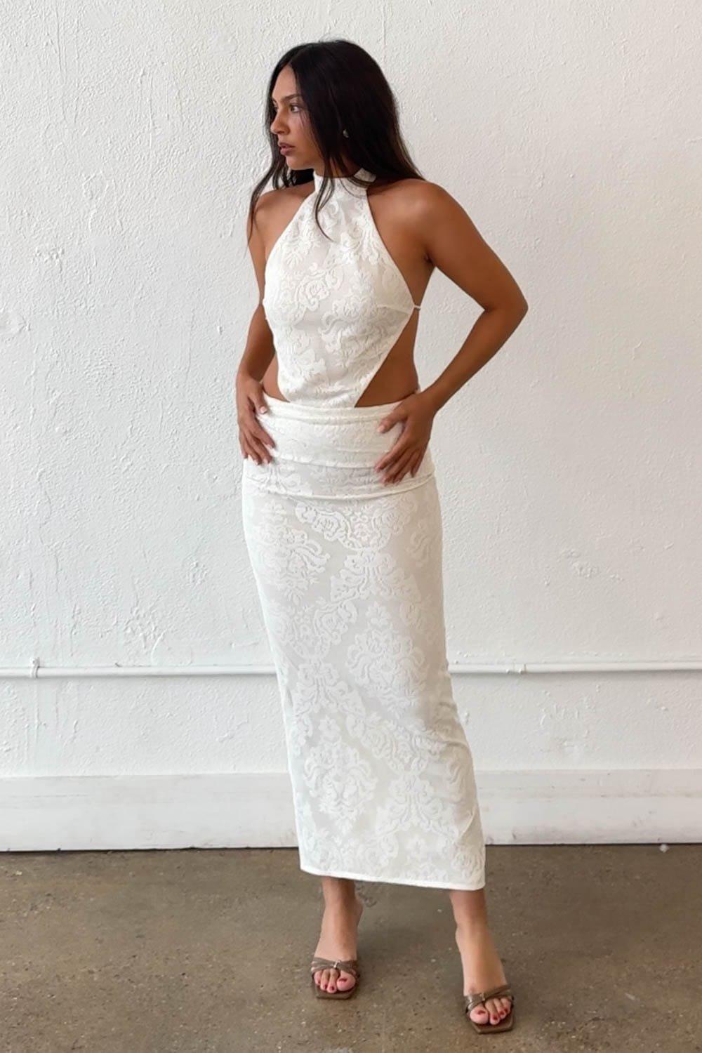 A Bold And Striking Maxi Dress Featuring A High Halter Neckline With An Open Back Tie Closure And Dramatic Side Cut-Outs At The Waist. The Lace-Pattern Fabric, Low Rise Skirt With A Ruched Waistband, And Back Center Slit Create A Show-Stopping Silhouette Perfect For Evening Events Or Resort Styling. Fully Lined Skirt. – High Mock Halter Neckline – Open Back With Self-Tie Closure – Side Cut-Out Detail At Waist – Low Rise Lace-Pattern Skirt With Ruched Waistband – Back Center Slit – Fully Lined Skirt – Non-Stretch Structured Fabric Fabric Content: (S7909D) image