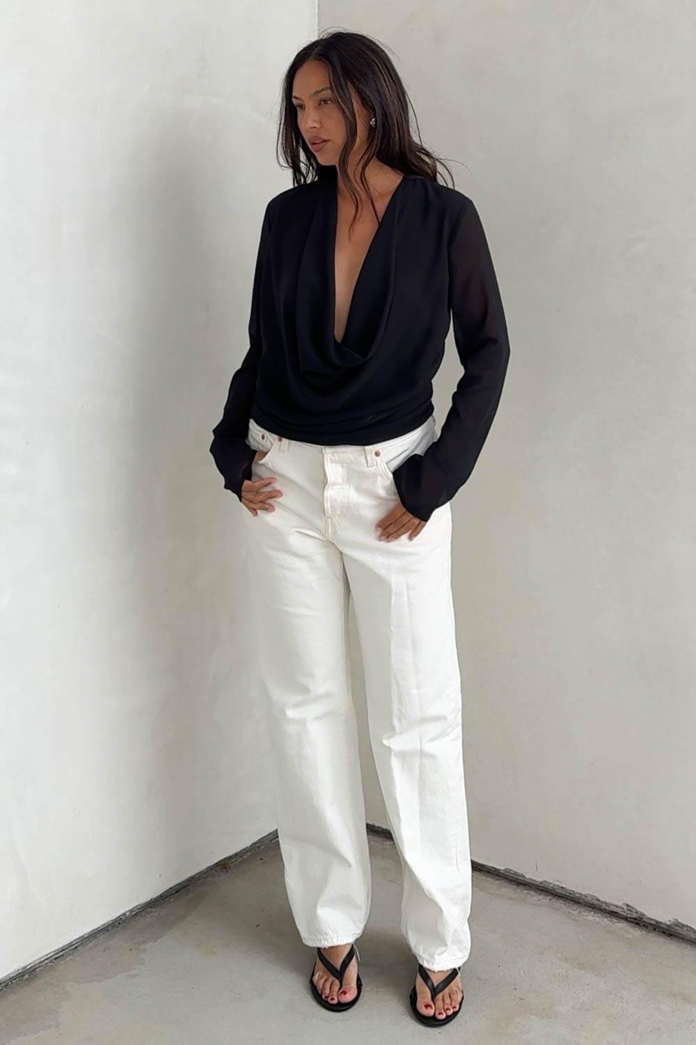 This Beautiful Blouse Features A Deep Plunging Cowl Neckline That Drapes Gracefully Across The Front To Create A Fluid, Layered Effect. It Is Designed With Semi-Sheer Long Sleeves And A Relaxed Yet Clean Silhouette That Easily Tucks Into Your Favorite Bottoms. Style This Versatile Black Top With High-Waisted White Denim Or Wide-Leg Trousers For A Polished, Contrasting Casual-Chic Look, Or Pair It With A Sleek Satin Skirt And Heels For An Elevated Night Out. – Sophisticated Long-Sleeve Blouse Featuring A Dramatic, Plunging Deep Cowl Neckline – Elegant Draped Fabrication Across The Front Torso That Adds Fluid Dimension And Movement – Versatile Statement Piece Perfect For Sophisticated Date Nights, Evening Cocktail Parties, Or Upscale Dinners Fabric Content: (S7645T) image