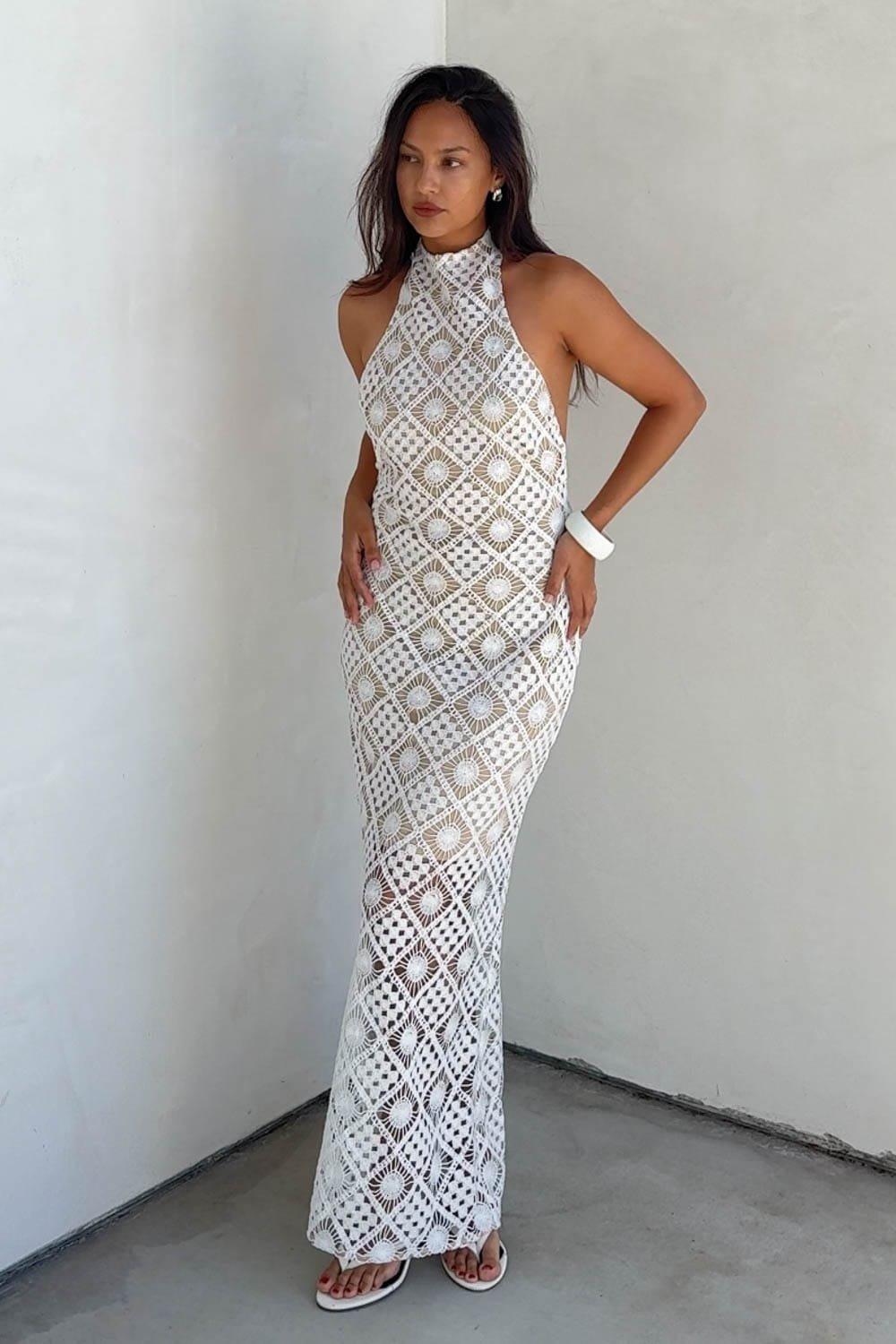 An Exquisite And Breathtaking Crochet Maxi Dress Featuring A High Halter Neckline And An Alluring Low Back Design. Perfect For Special Summer Events, Style This Sophisticated Backless Dress With Minimal Strappy Heels And Gold Jewelry For A Striking Resort Evening Look, Beach Wedding Guest Ensemble, Or An Upscale Tropical Vacation Outfit. – Intricate Geometric Crochet Lace Overlay Delivering A Rich, Textured, And Bohemian-Chic Look – Flattering Body-Skimming Column Silhouette With A Contrast Lining For Beautiful Dimension – Sheer Crochet Floor-Length Hem Detail Providing An Airy, High-Fashion Visual Contrast – Versatile Elegant Style Perfect For Beach Weddings, Summer Galas, And Premium Resort Vacations Fabric Content: (S7816D) image